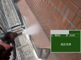 大阪府茨木市の外壁塗装現場での庇部分の高圧洗浄作業。雨だれ汚れと旧塗膜を除去している状況。