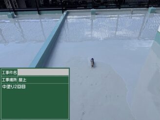 大阪市港区の雨漏り対策で屋上全面に防水材の中塗り2回目を施工している写真