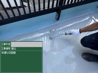 大阪市港区の屋上防水工事で通気緩衝工法の中塗り1回目を施工している写真