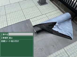 大阪市港区の屋上防水で通気緩衝工法の自着シートを貼り付けている写真