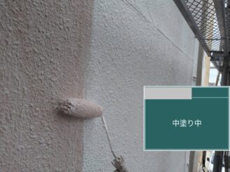 大阪市港区の外壁塗装工事で外壁の中塗りを施工している様子