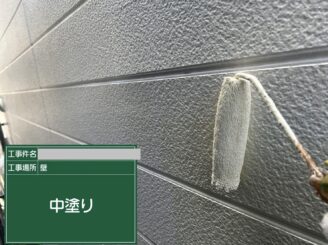 大阪市此花区の外壁塗装工事で住宅外壁の中塗り塗装を行っている様子